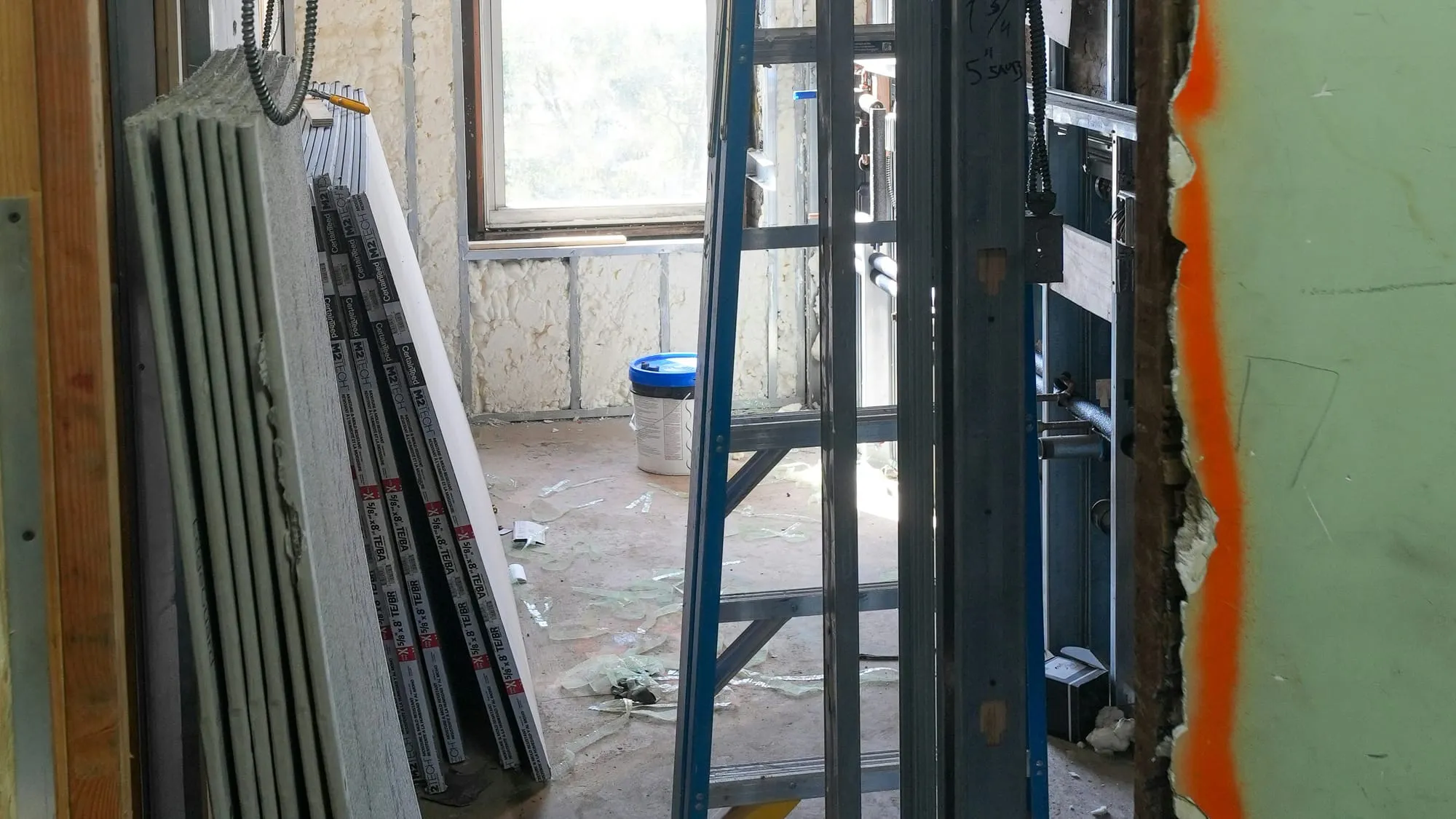 Chantier de cloisons sèches : plaques de plâtre empilées et rails métalliques