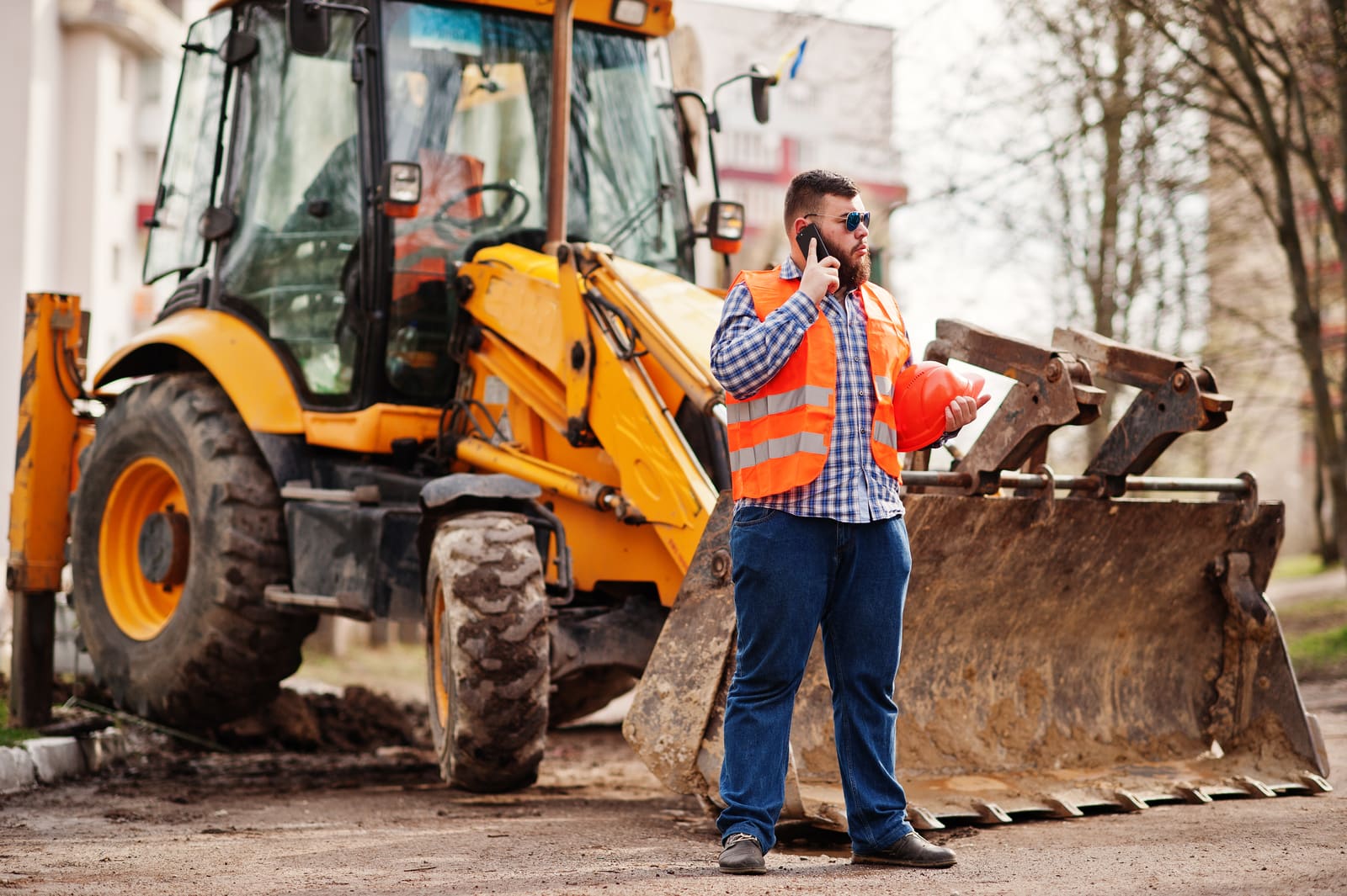 Professionnel du BTP devant son engin de chantier